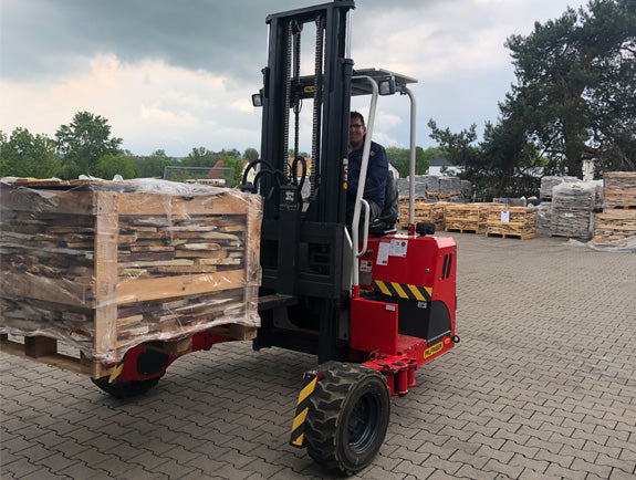Mitarbeiter von Schwedt Logistik transportiert palettierte Natursteinware mit einem Gabelstapler